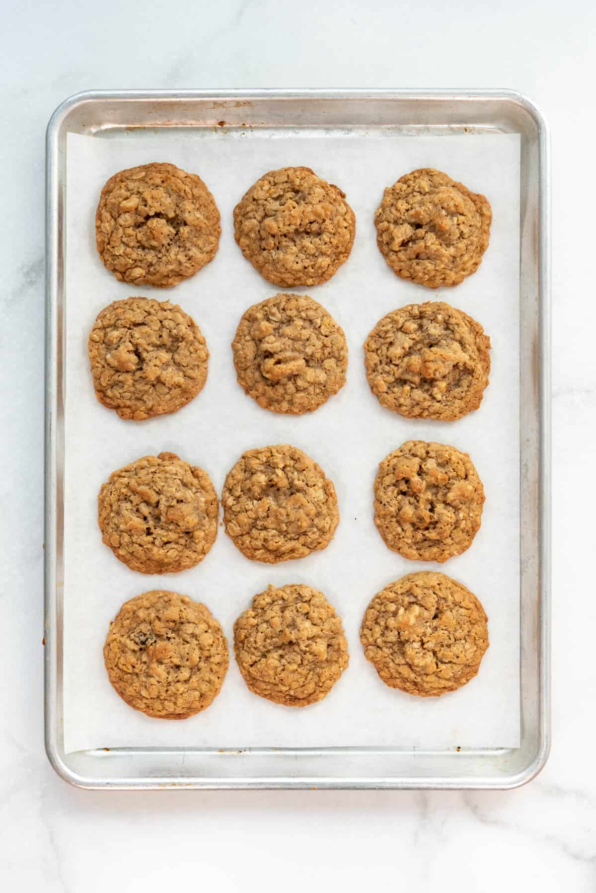 Baked ranger cookies on a baking sheet lined with parchment paper.
