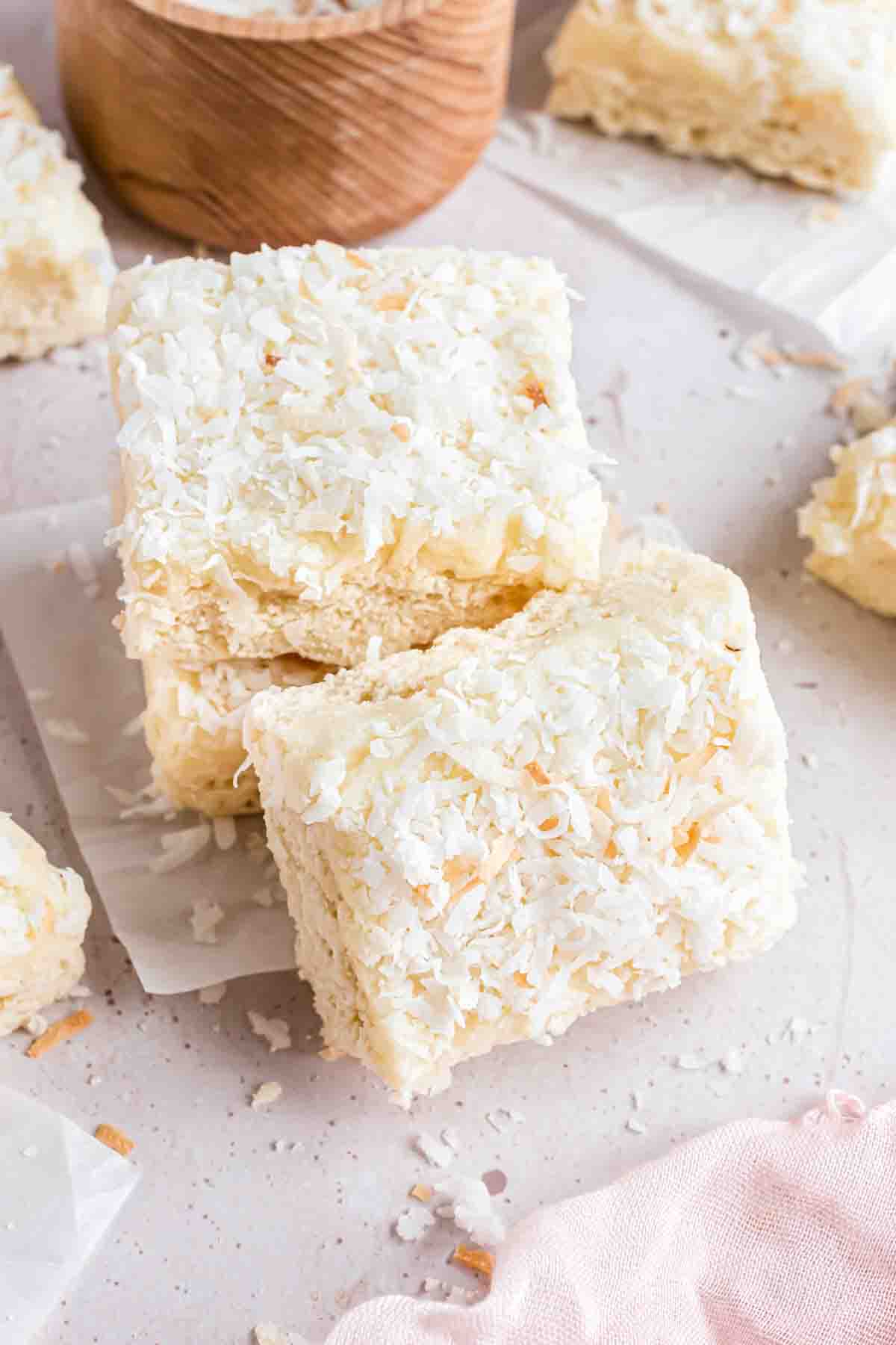 A stack of coconut sugar cookie bars with one leaning against it.