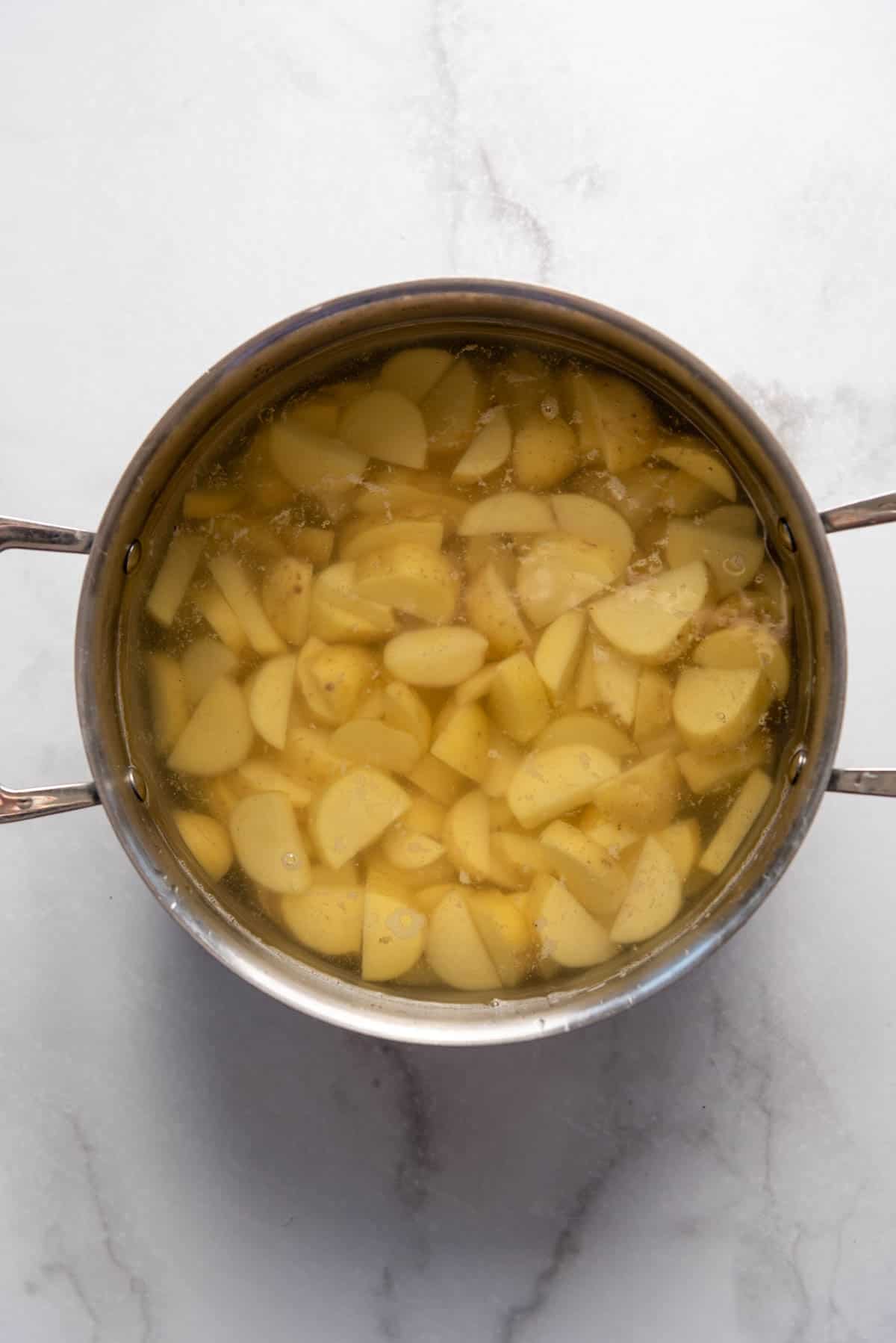 Cooking Yukon gold potatoes in a large pot of water.