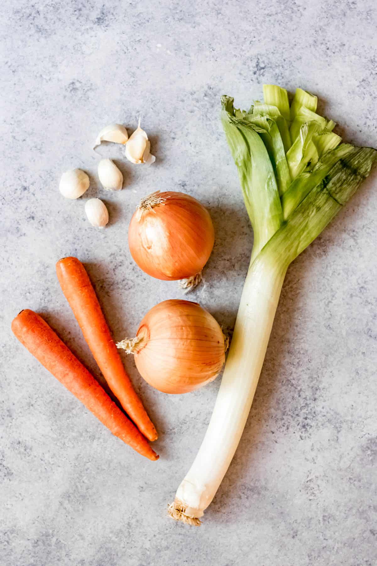 Onion, carrots, garlic, Leeks getting ready to be chopped.
