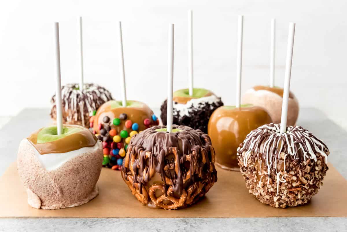 An image of 8 caramel apples with different toppings.