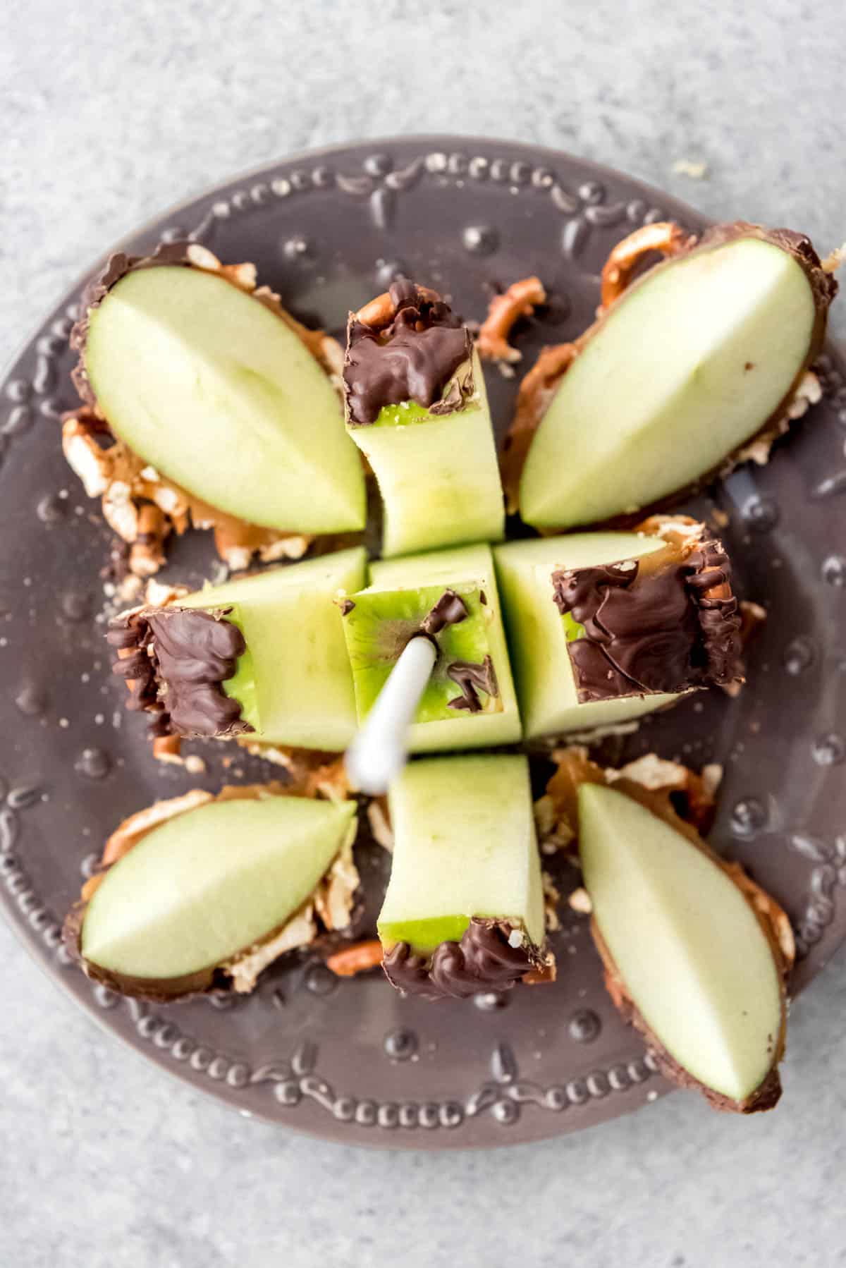 An image of a caramel apple that has been cut into segments for easier eating.
