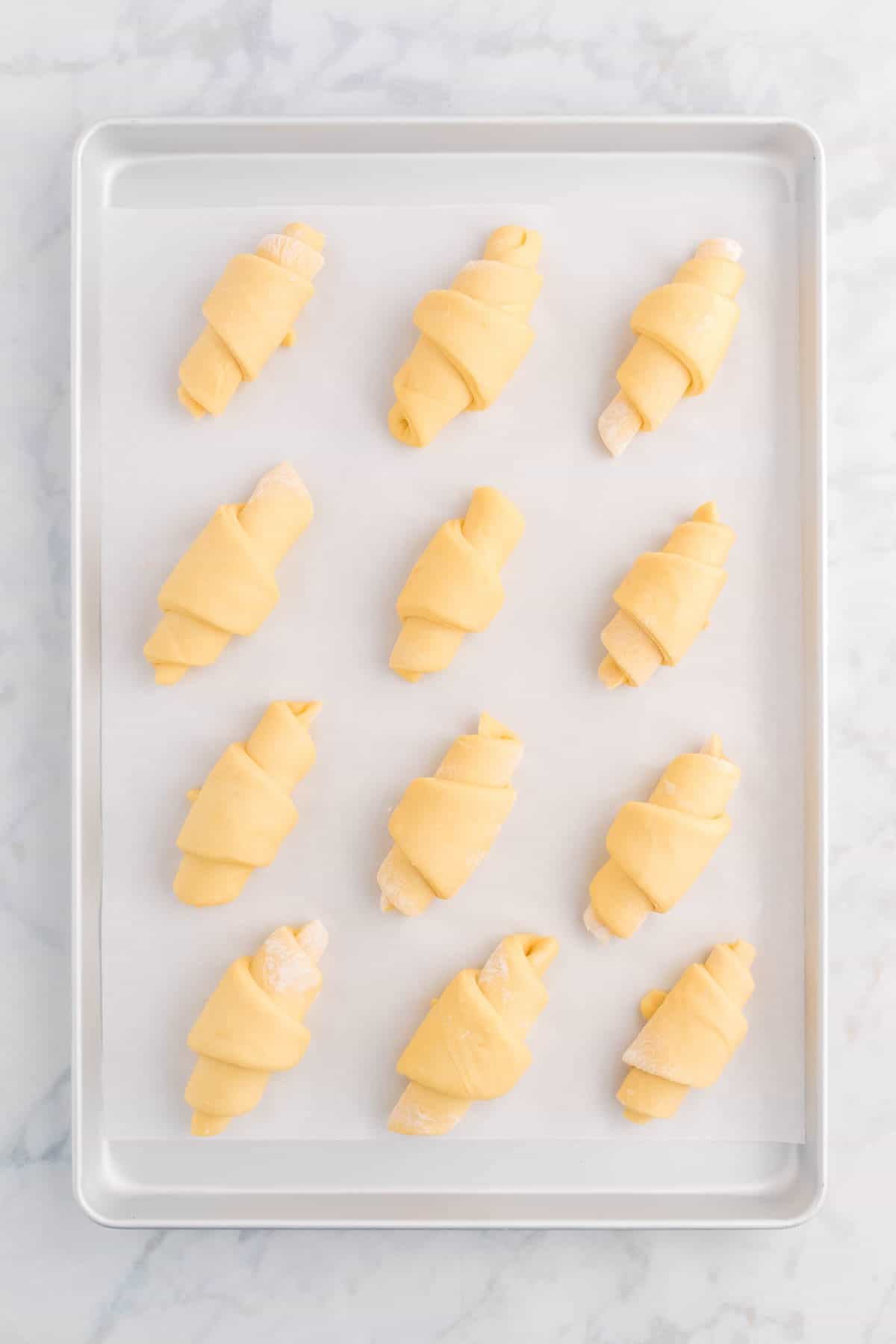 Top view of uncooked crescent rolls on a baking sheet. 