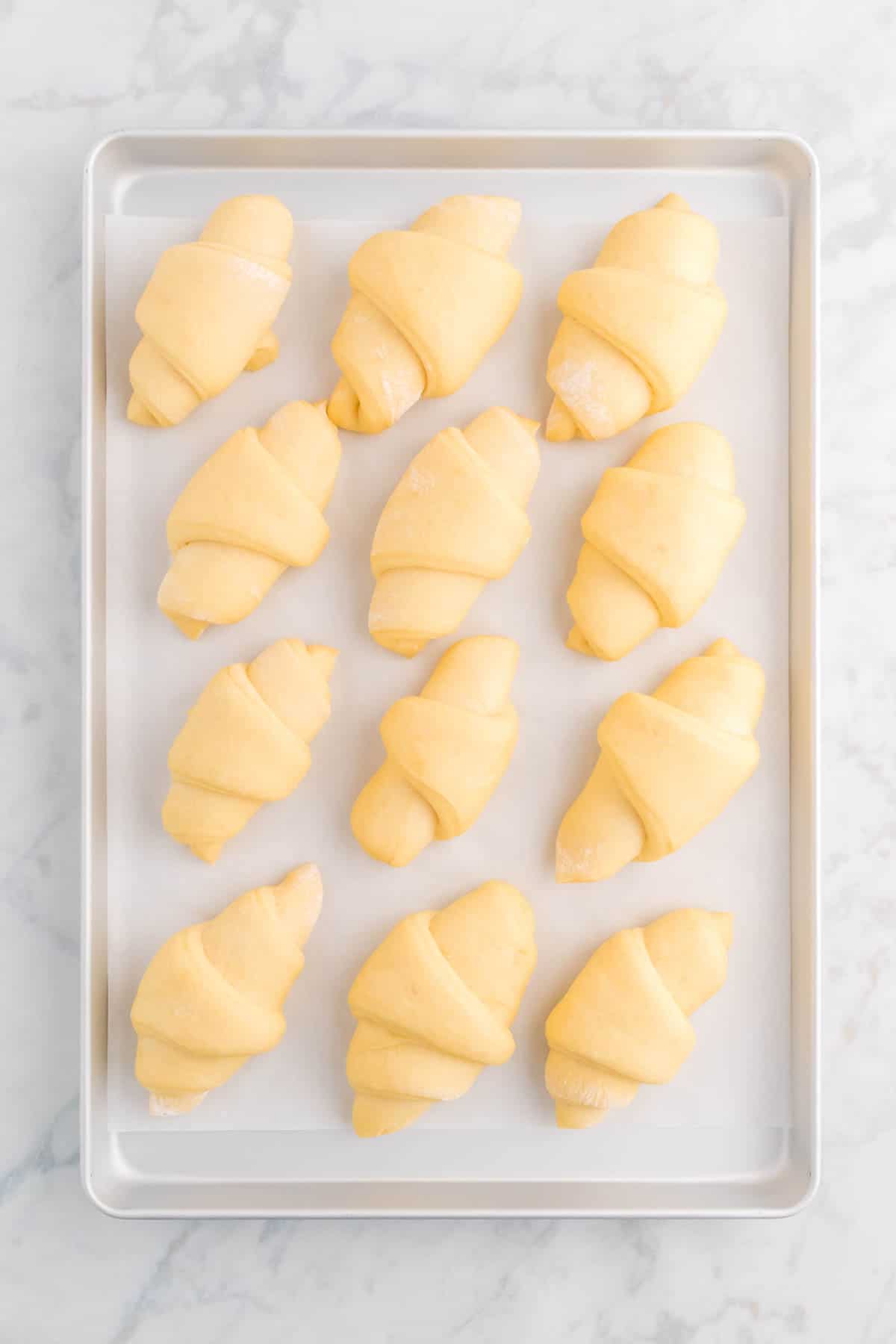 Top view of risen and unbaked crescent rolls.
