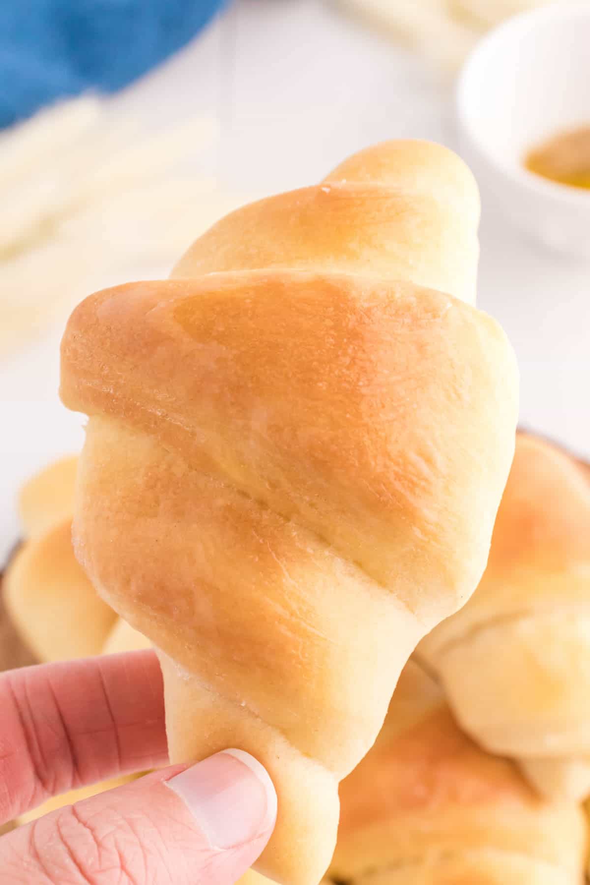 Close up of a crescent roll being held in mid air.