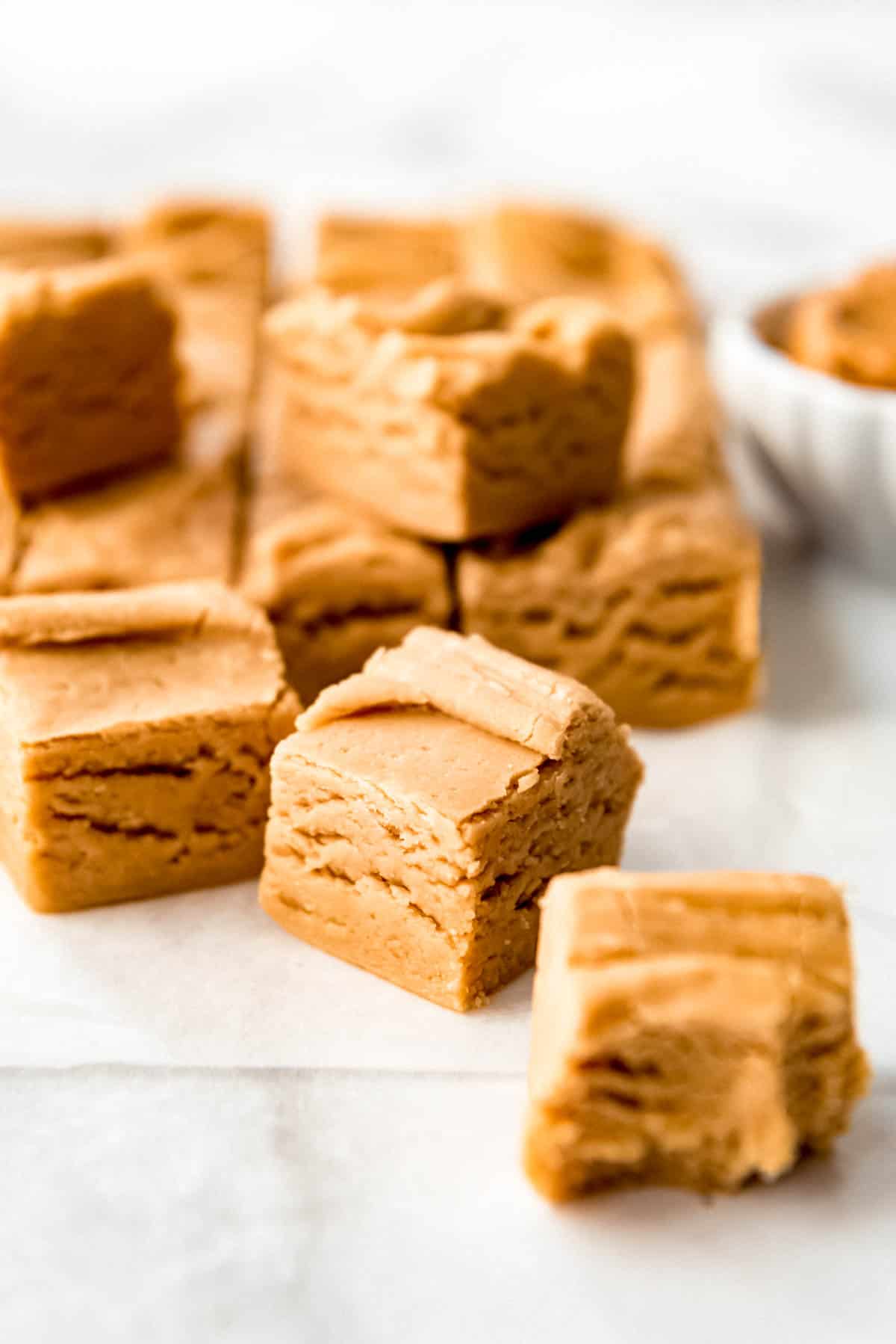 Close up of small squares of creamy peanut butter fudge.
