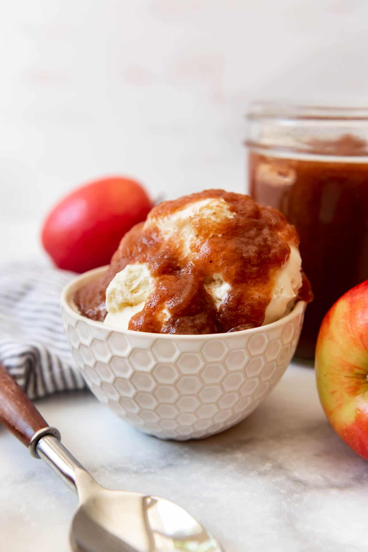Ice cream in a bowl topped with apple butter.