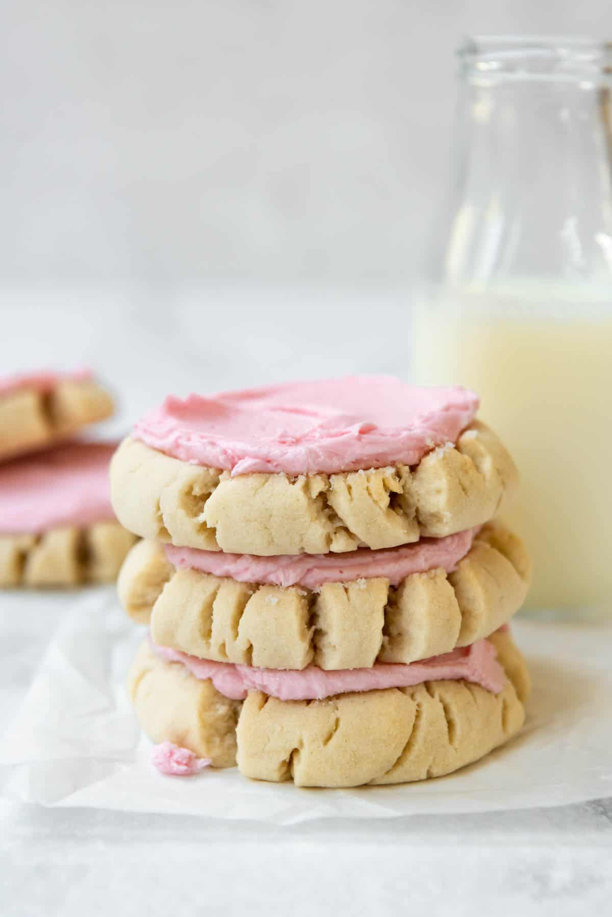 A stack of three frosted sugar cookies.