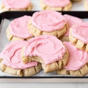 Pink frosted Swig sugar cookies with a bite taken out of one of them.