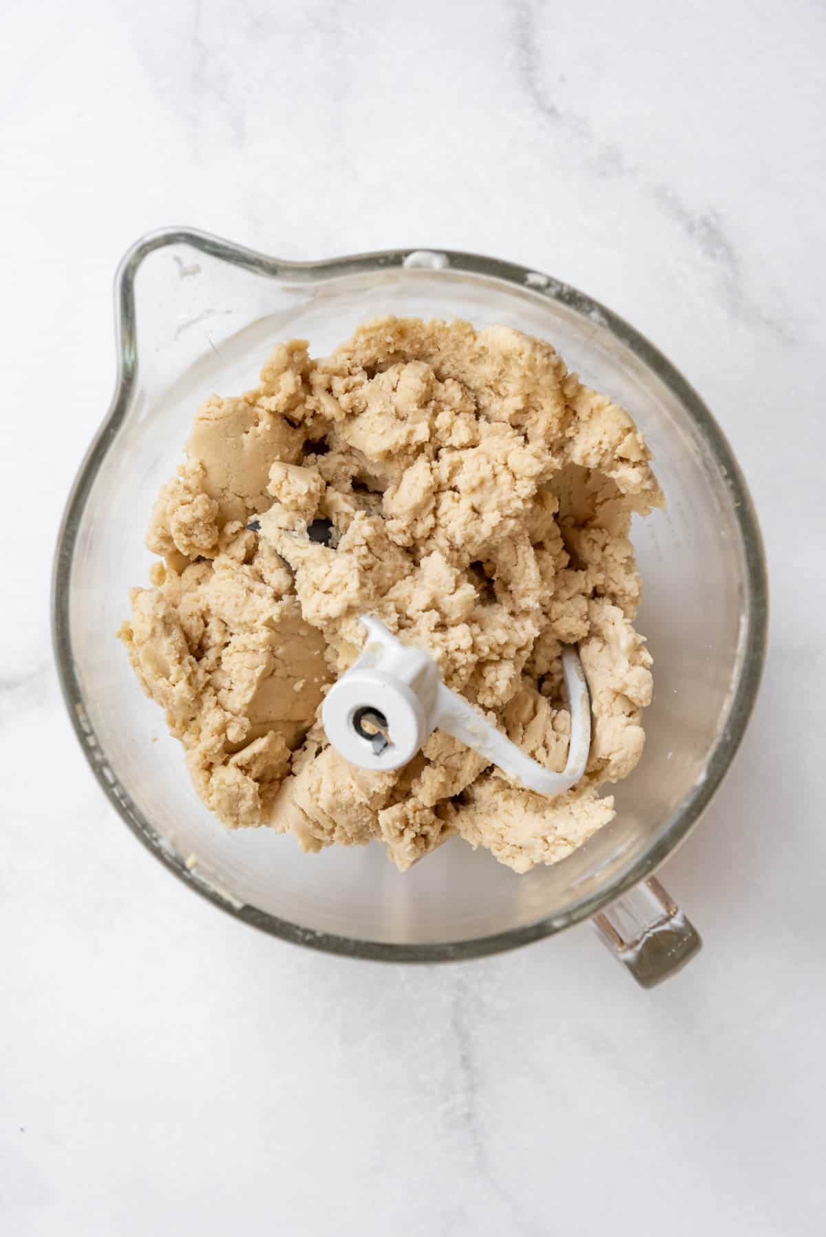 Sugar cookie dough in a glass mixing bowl.