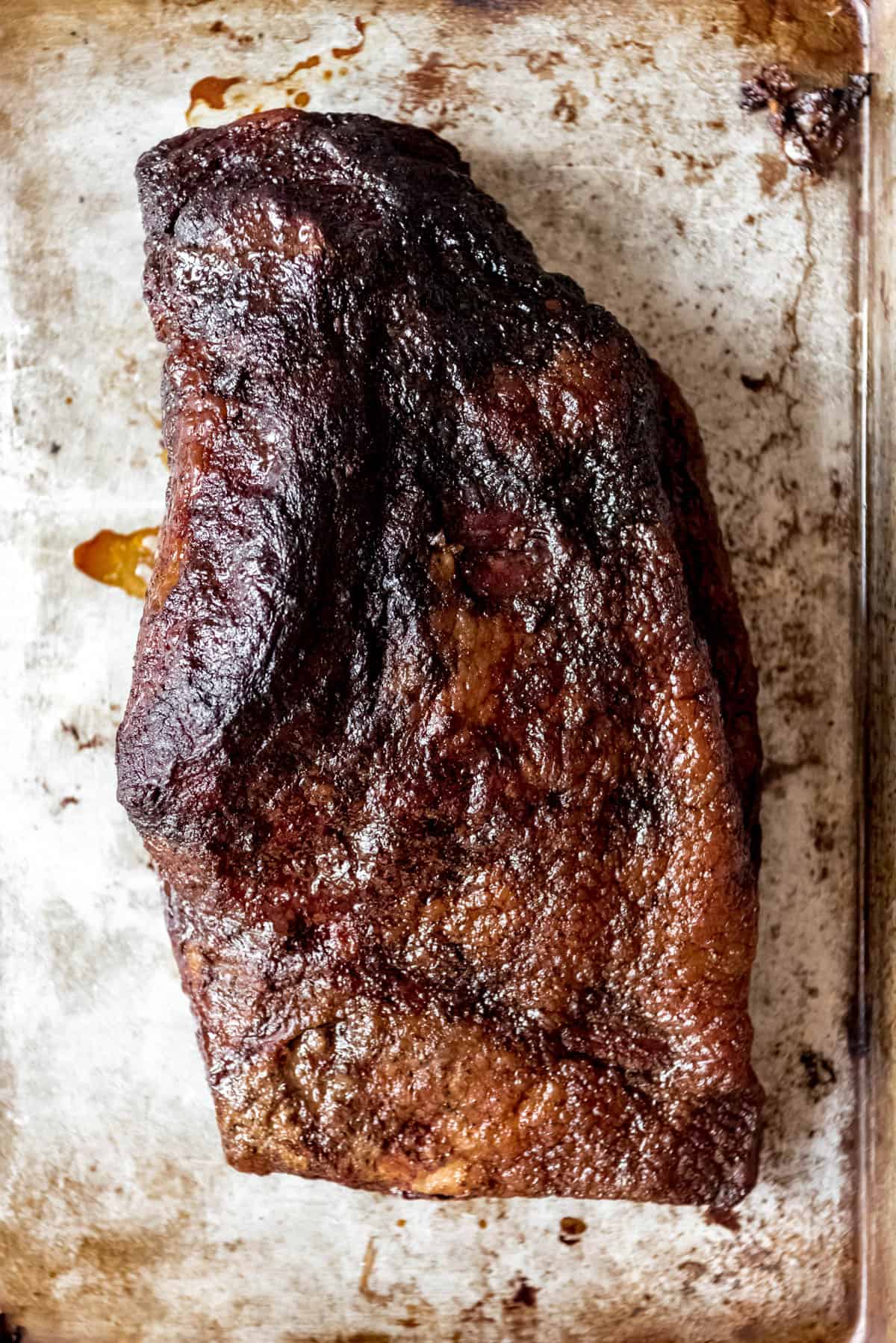An image of a whole smoked beef brisket resting before being sliced.