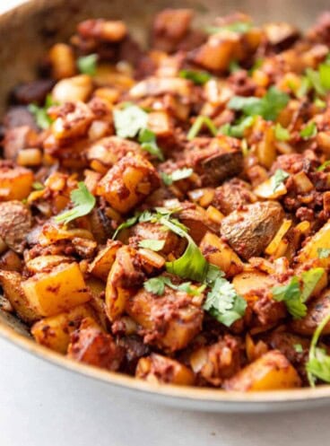 Close up of a pan filled with potatoes and chorizo.