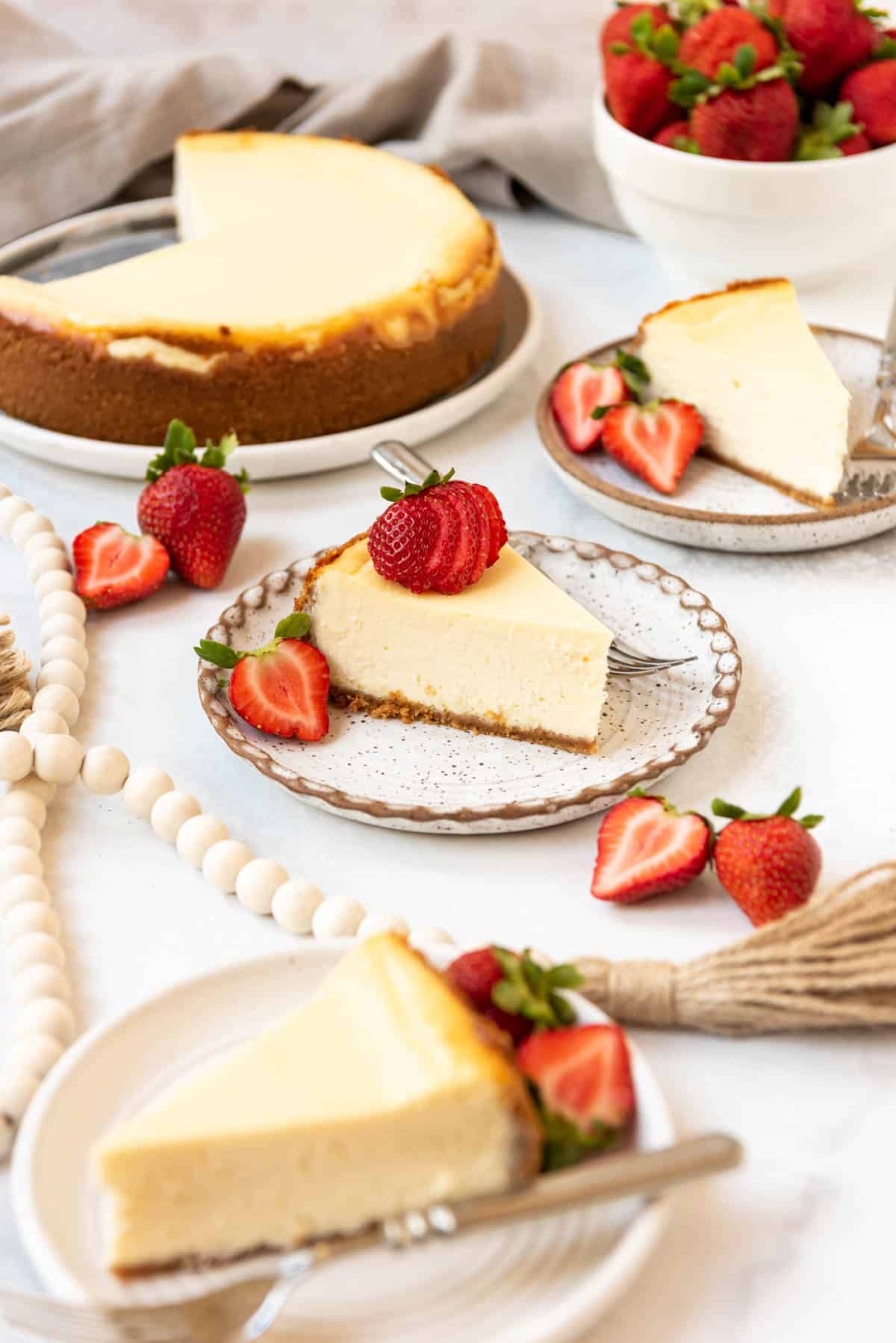 Table filled with sliced of the BEST cheesecake on plates. 