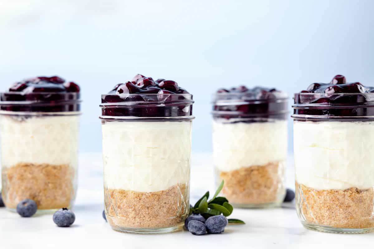 Four homemade blueberry cheesecake jars.