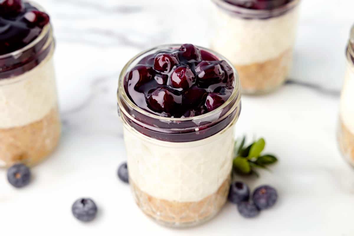 Cheesecake jars with blueberry filling on top.