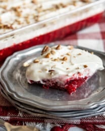 Cranberry Jell-O Salad served on a gray plate with a baking dish in the background.