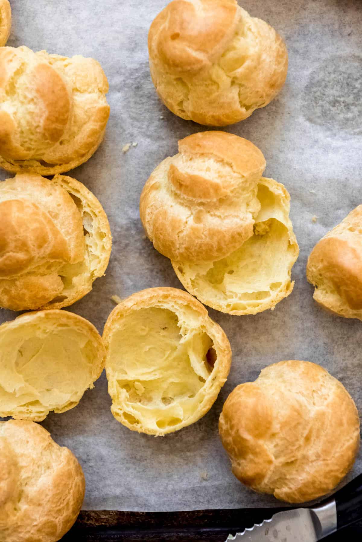 Homemade cream puffs that have been sliced open.