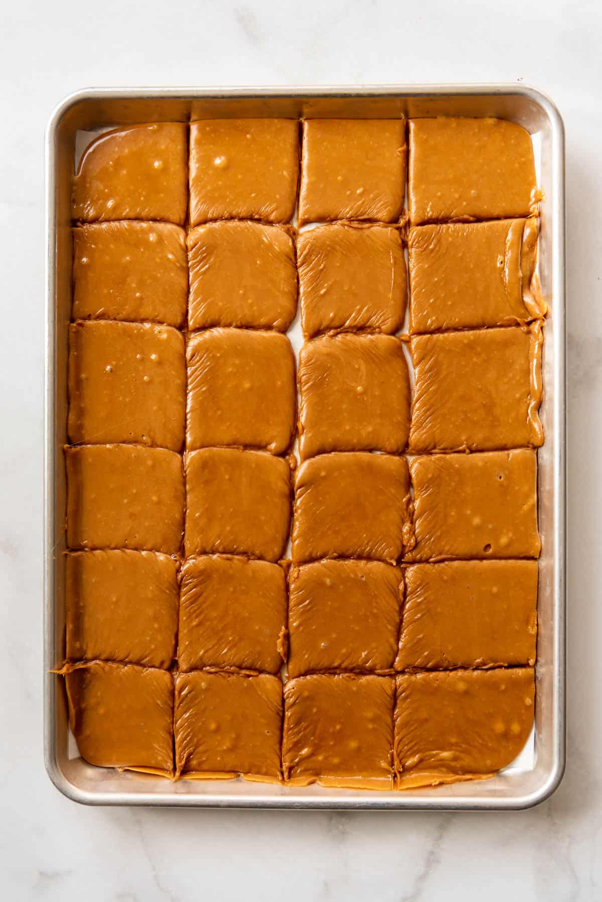 an image of freshly cut toffe squares in a baking sheet.