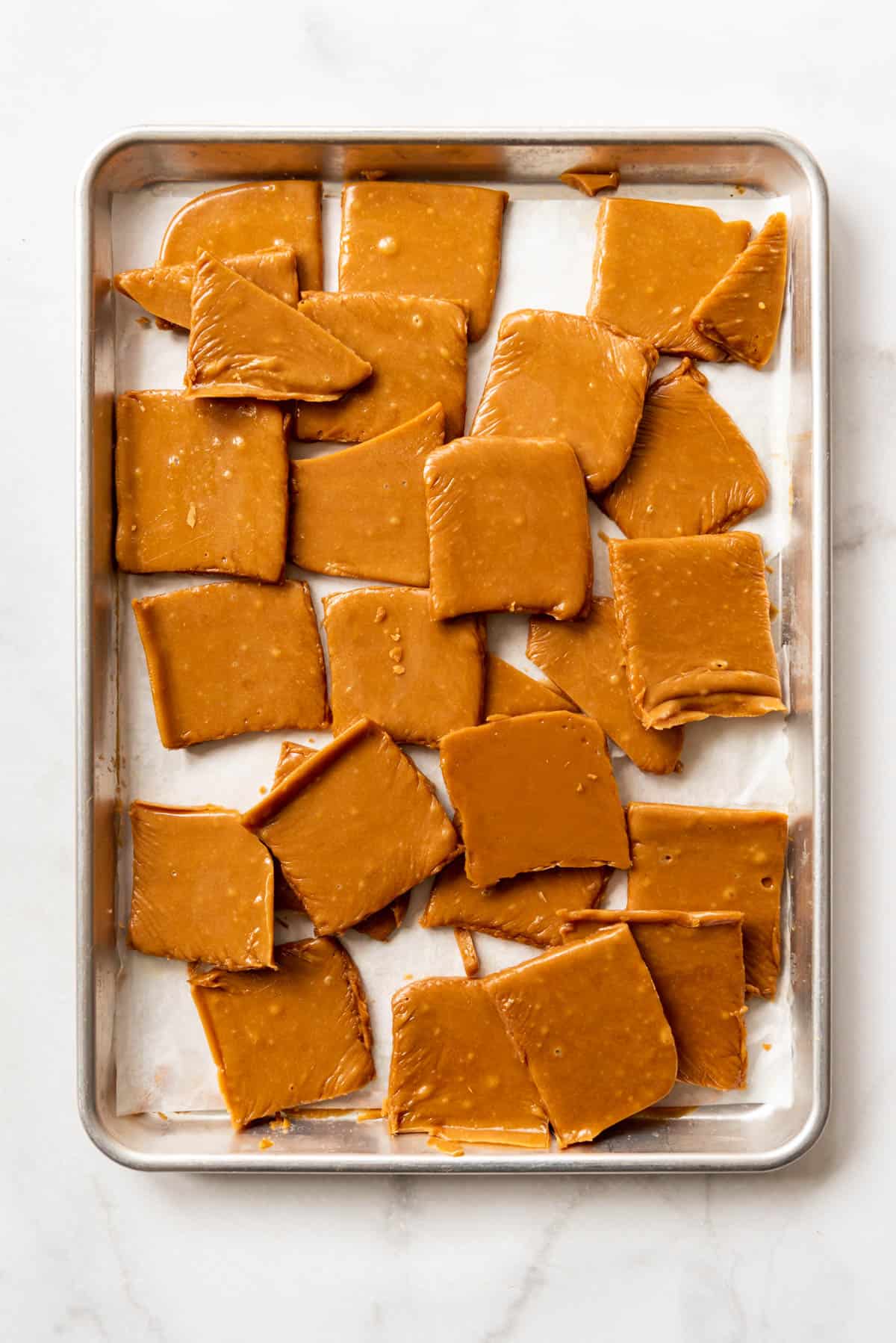 An image of churro toffee squares cut up in a baking sheet.