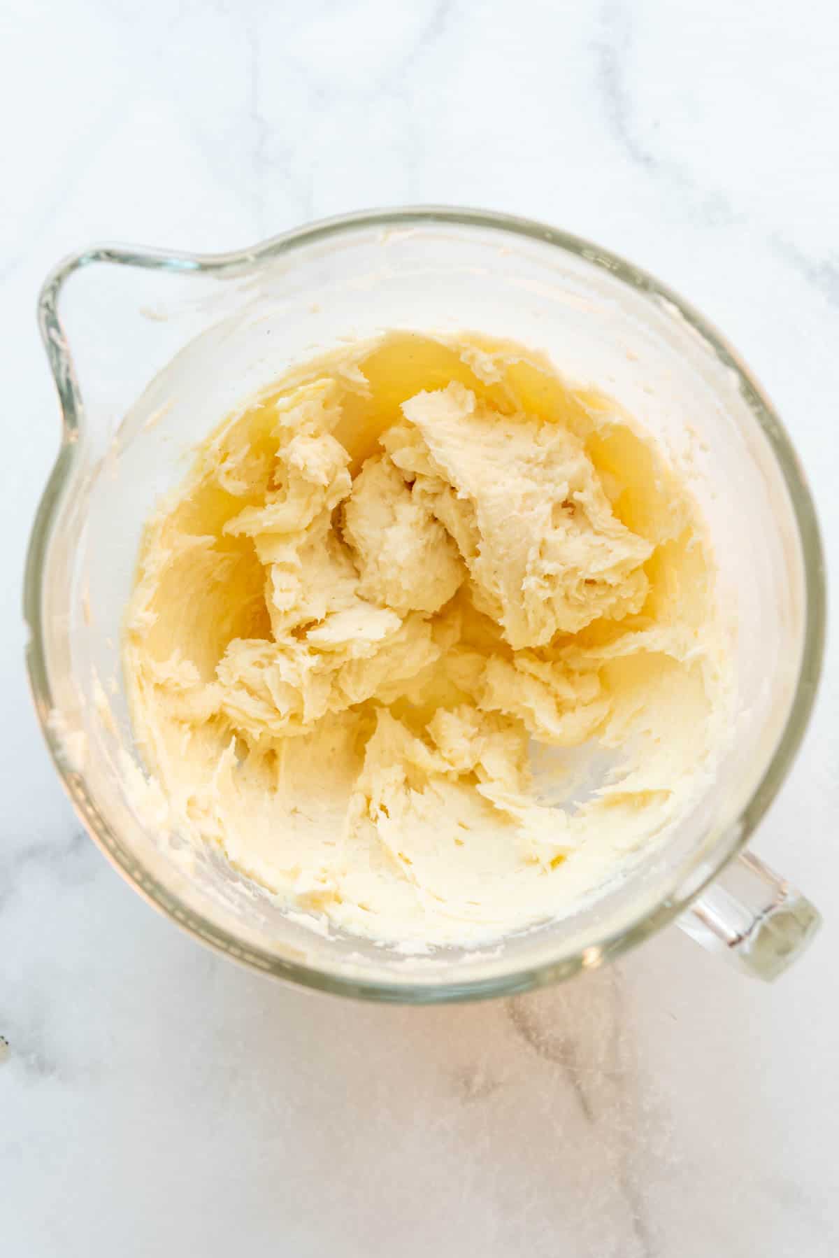 Creamed butter and sugar in a glass mixing bowl.