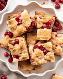 Fresh cranberry shortbread bars on a white plate.