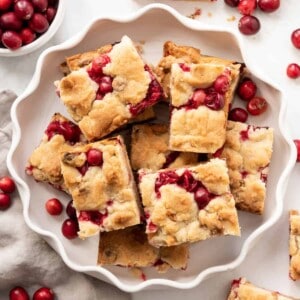 Fresh cranberry shortbread bars on a white plate.