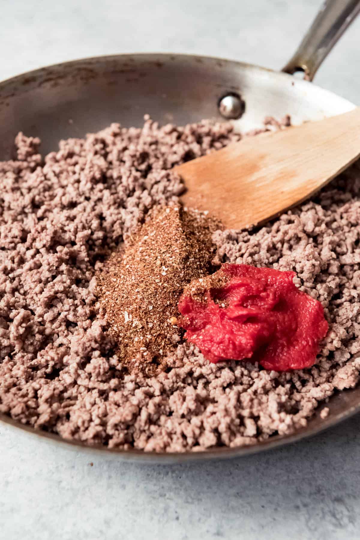 An image of a pan of browned ground beef with homemade taco seasoning and tomato paste.