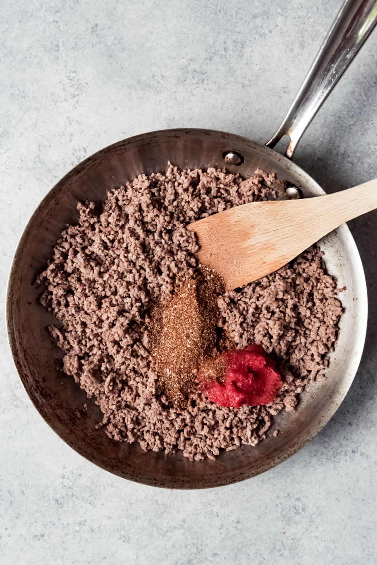 An image of browned ground beef with homemade taco spice blend and tomato paste.