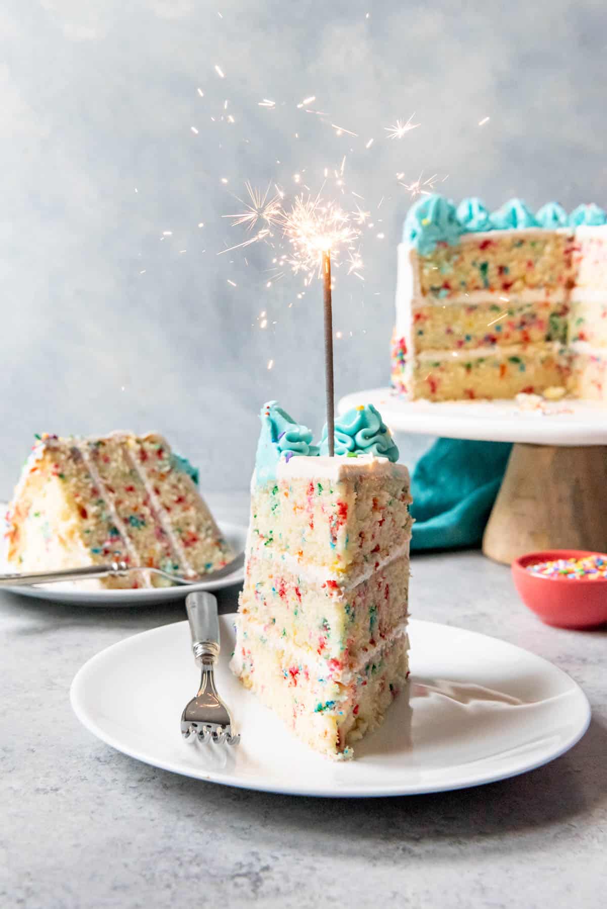 An image of a slice of birthday cake with a sparkler in it.