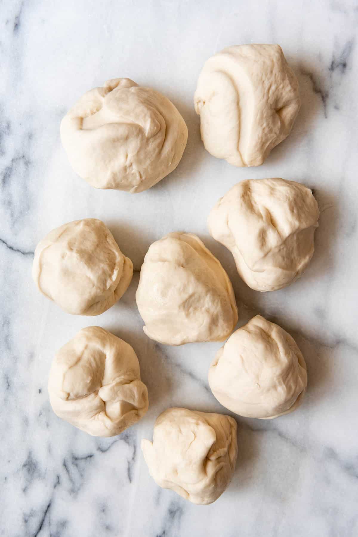 An image of pretzel dough rolled into eight separate balls.
