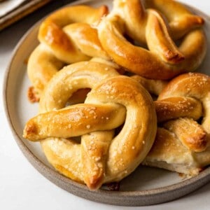An image of soft pretzels stacked on a plate.
