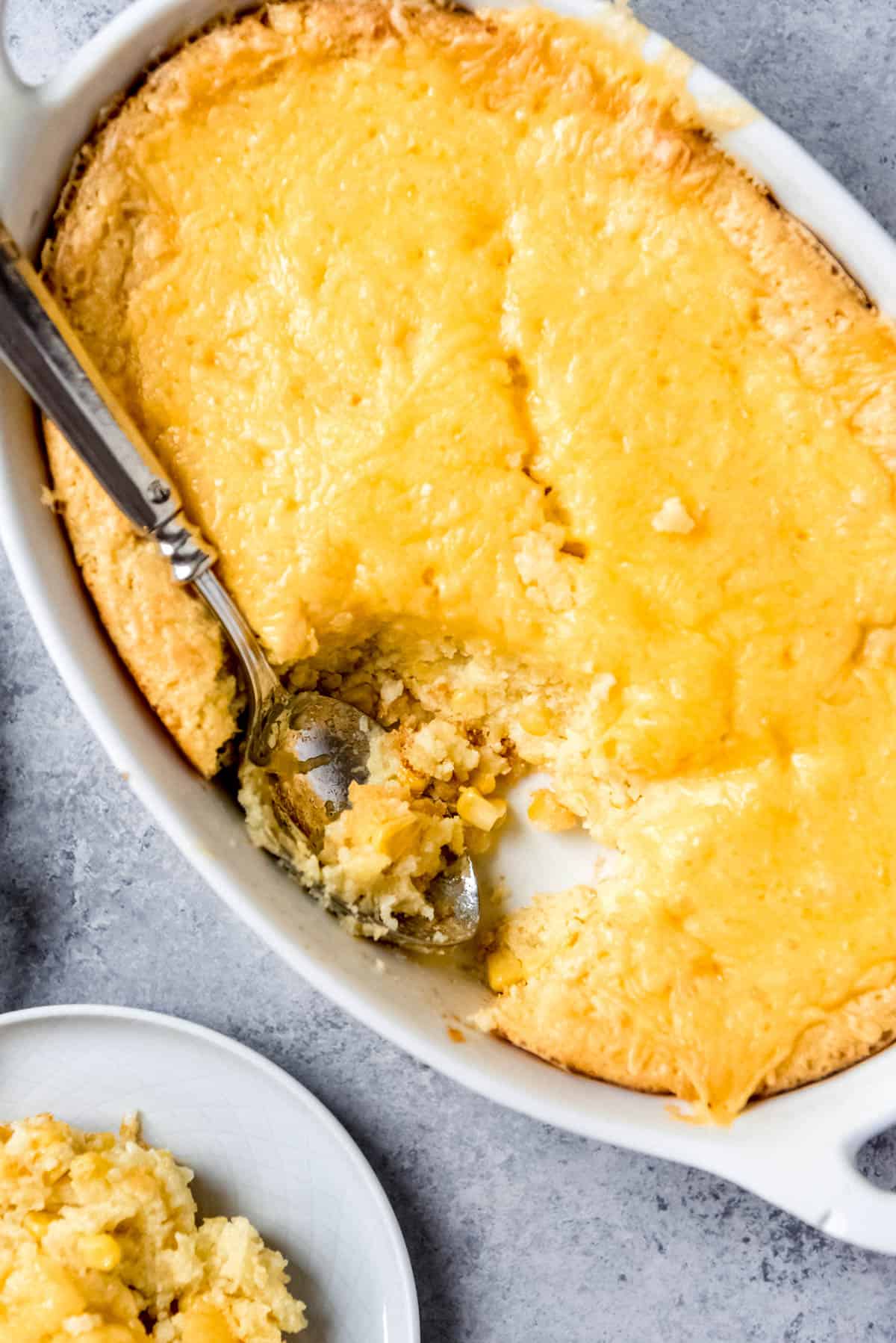 An image of corn spoon bread with a scoop taken out of it.
