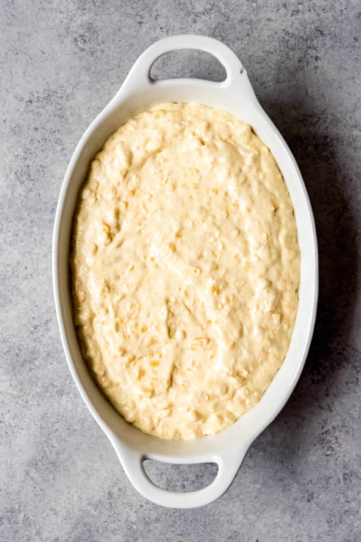 An image of a baking dish filled with corn casserole batter ready to go into the oven.