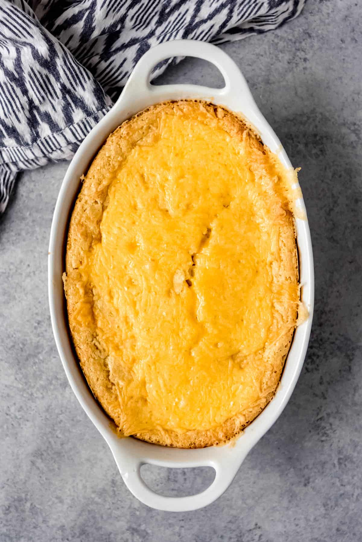 An Image of Baked Corn Casserole in an oval baking dish.