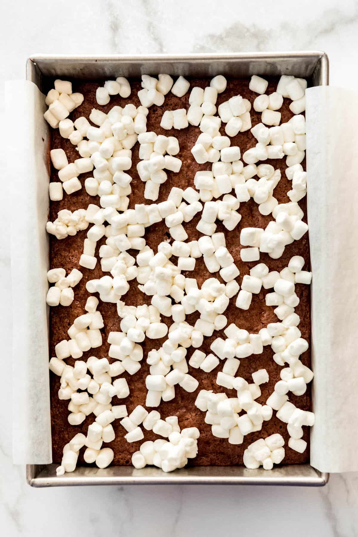 Mini marshmallows sprinkled over a pan of brownies.