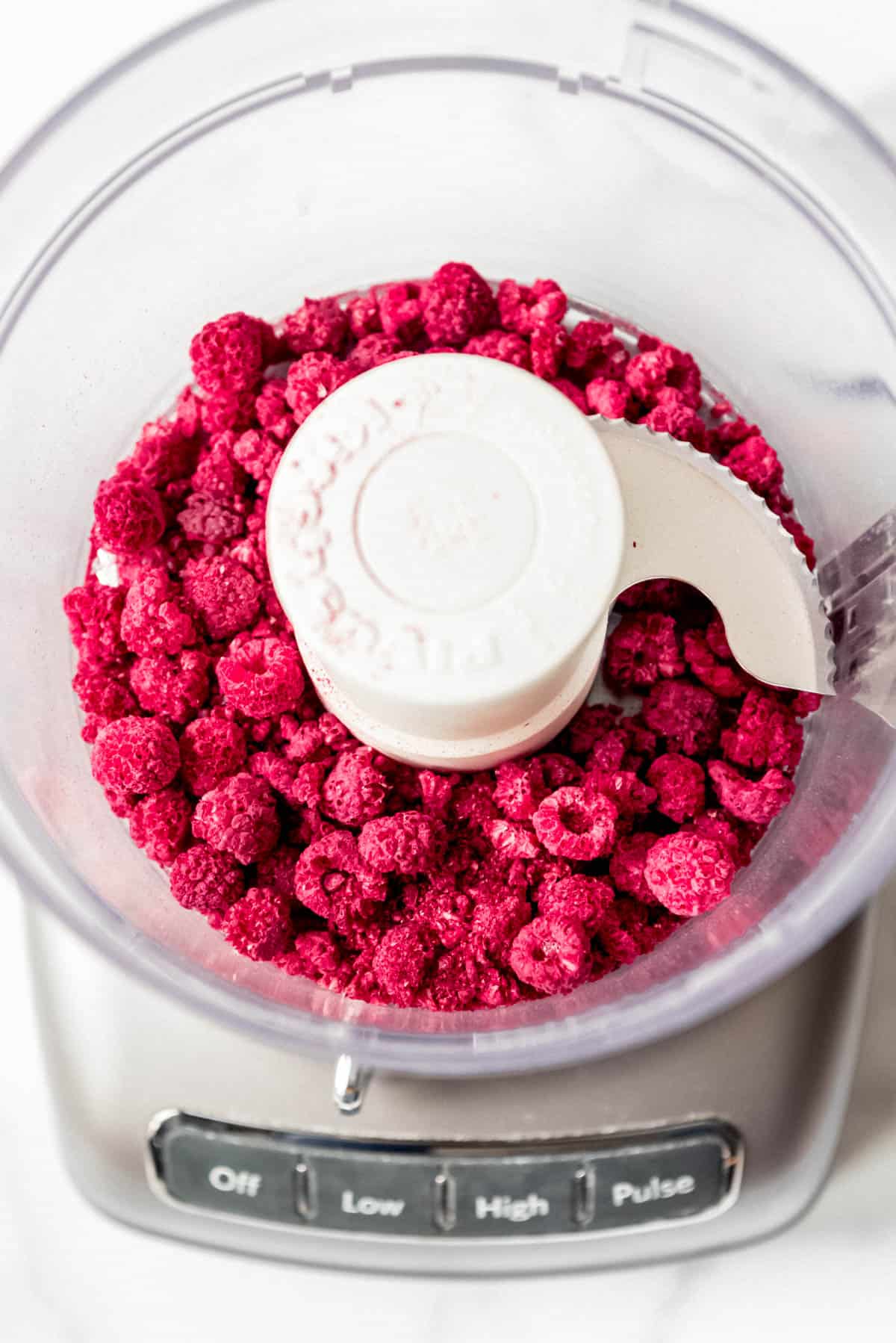 Freeze dried raspberries in food processor ready to be ground.