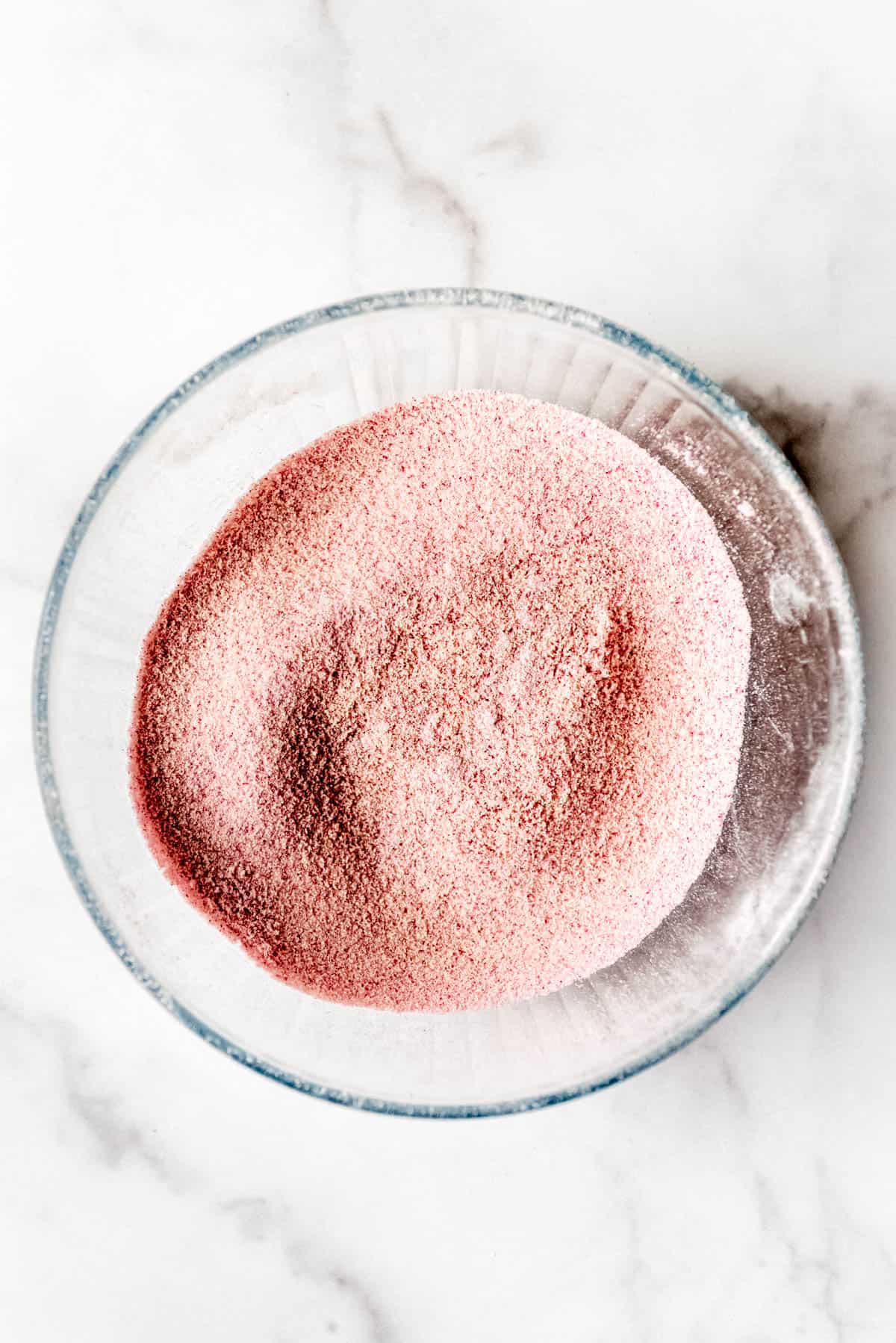 Powdered Ingredients for raspberry macarons sifted in bowl.