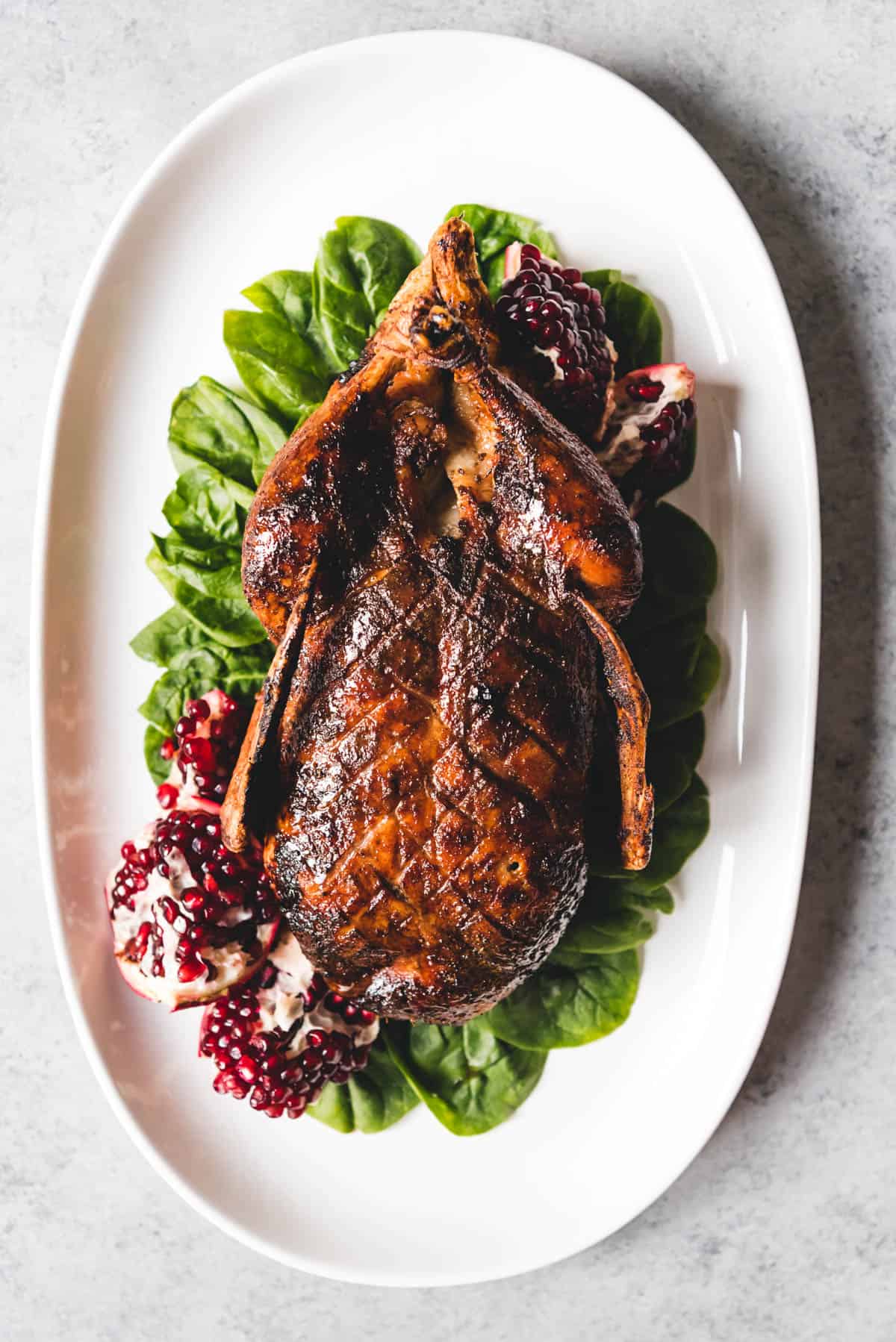 An image of a honey roasted duck served whole on a platter.