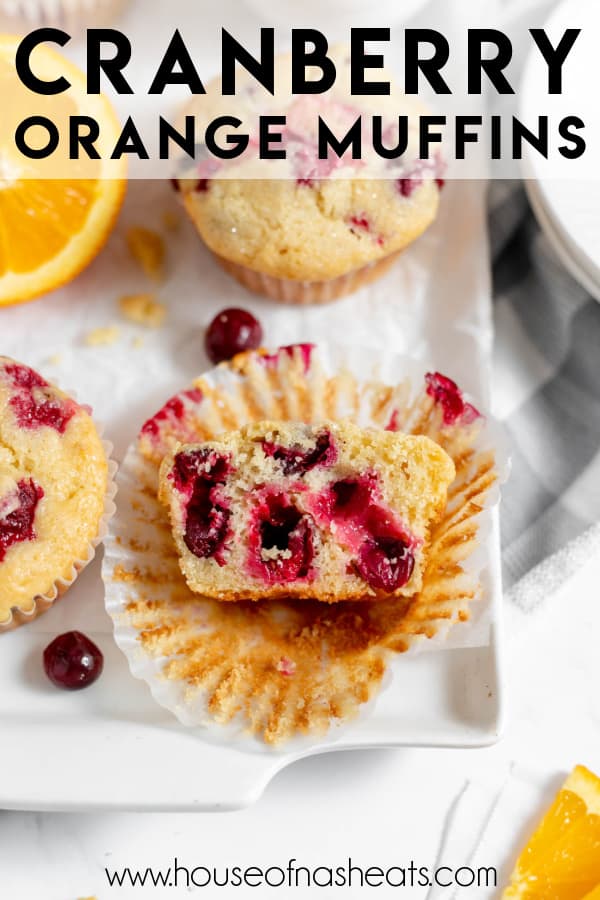 An unwrapped cranberry orange muffin that has been cut in half lying on its wrapper with text overlay.
