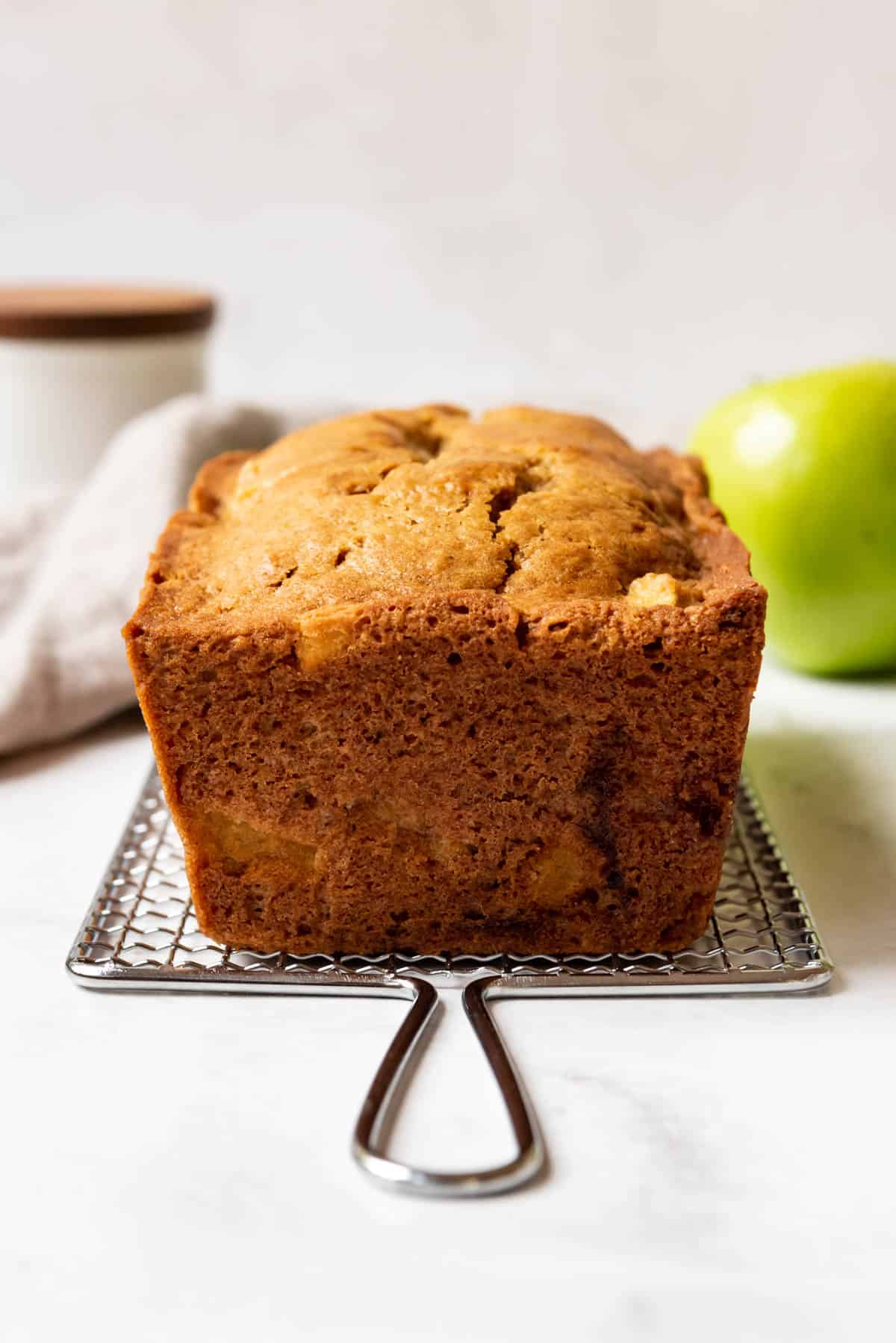 An apple loaf on a wire cooling rack.