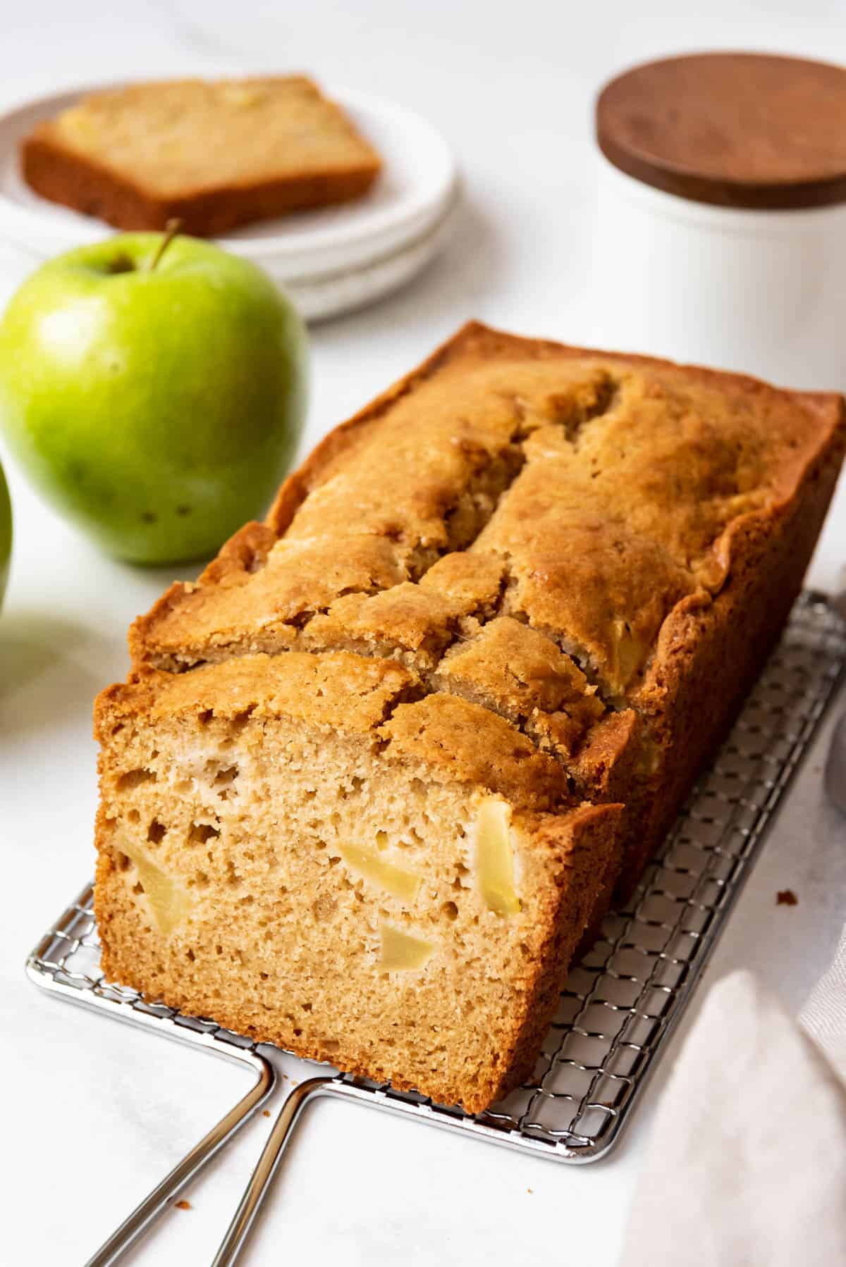A partially sliced loaf of apple quick bread.