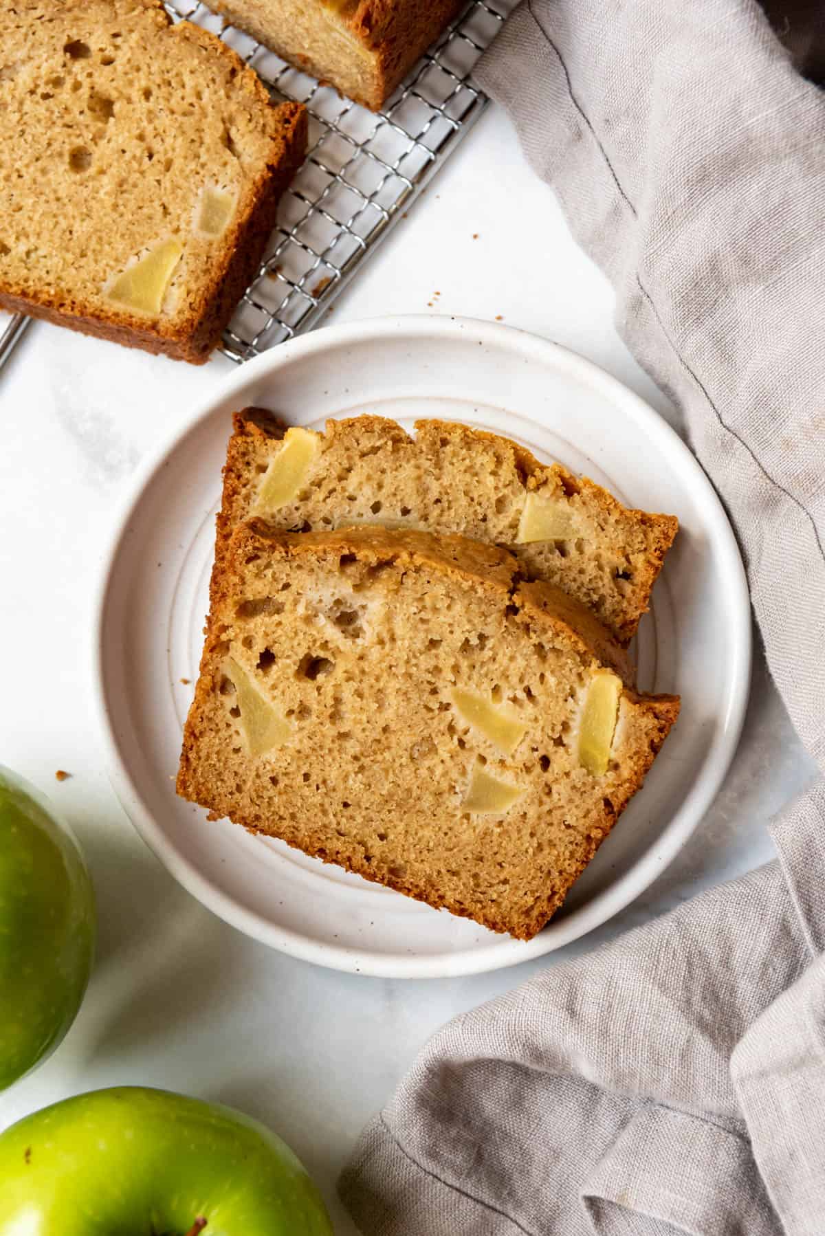 Two slices of apple ginger quick bread on a plate.