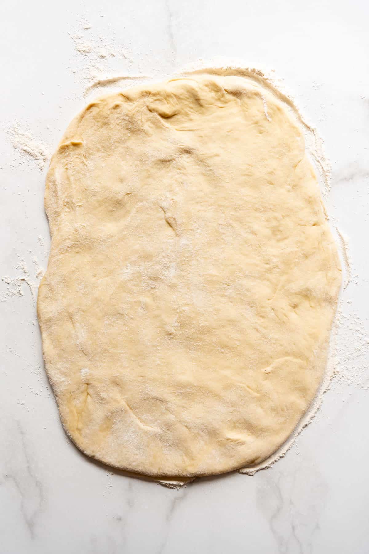 Rolling out soft roll dough onto a floured surface.