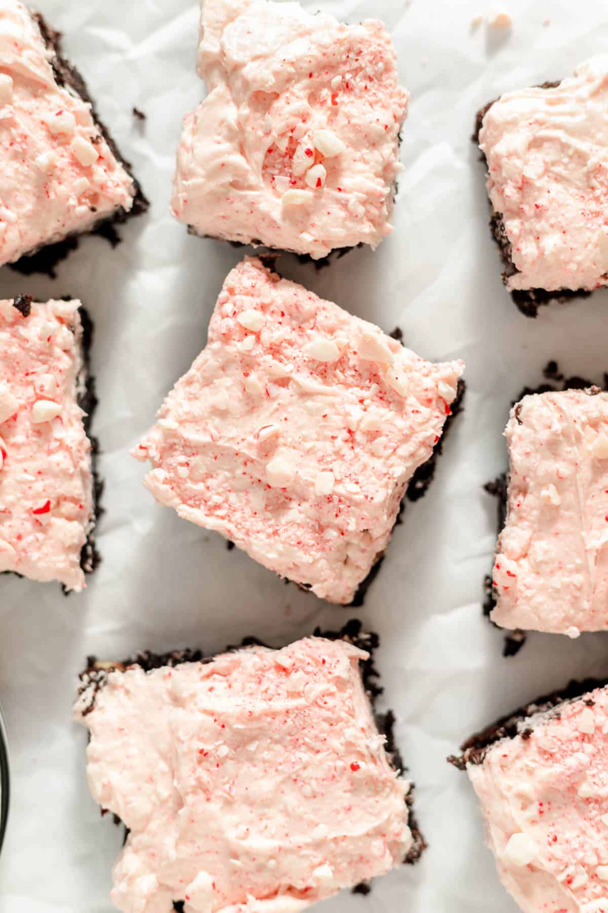 An image of brownies topped with peppermint frosting and crushed candy canes sprinkled on top.