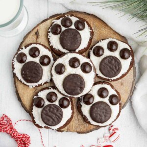 Six polar bear paw cookies made with Junior Mints and York Peppermint Patties on a wooden surface.