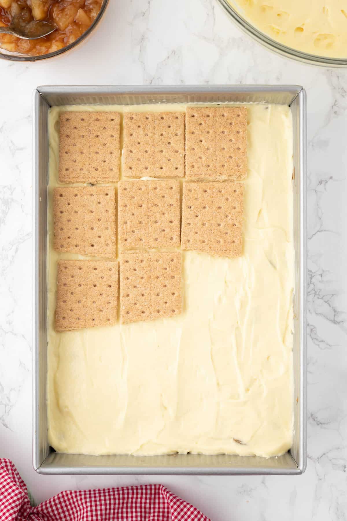 Adding another layer of graham crackers on top of the pudding layer.