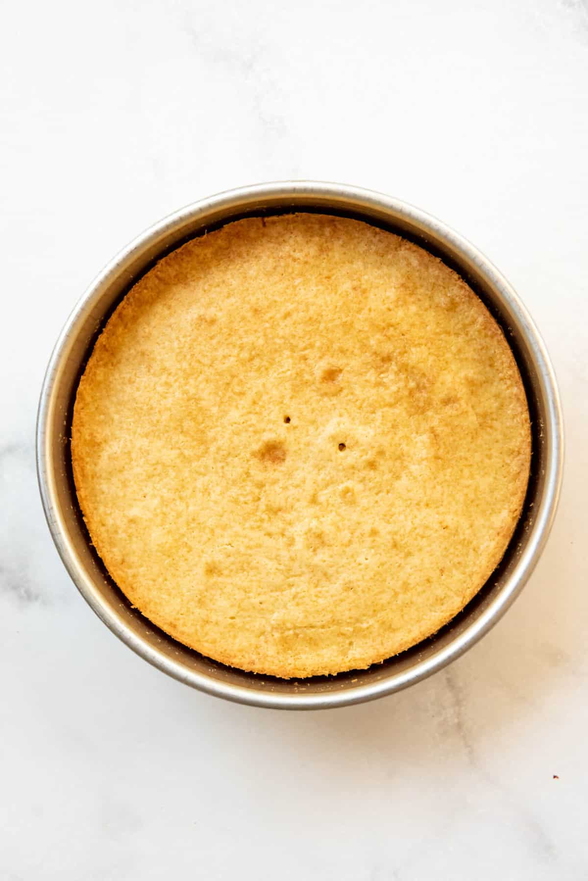 Baked cake layer for a homemade caramel cake in a 9-inch cake pan.