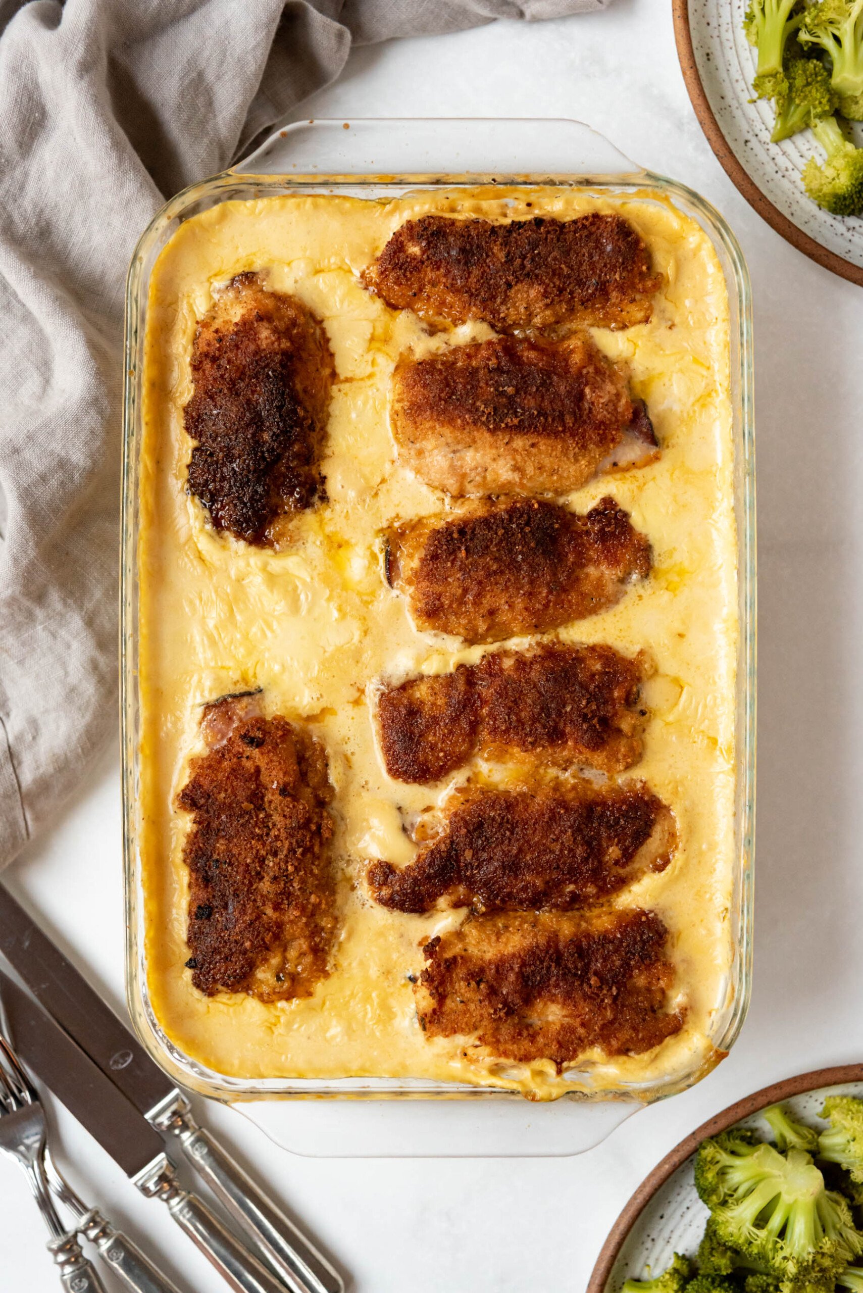 A casserole dish filled with chicken cordon bleu in a creamy sauce.