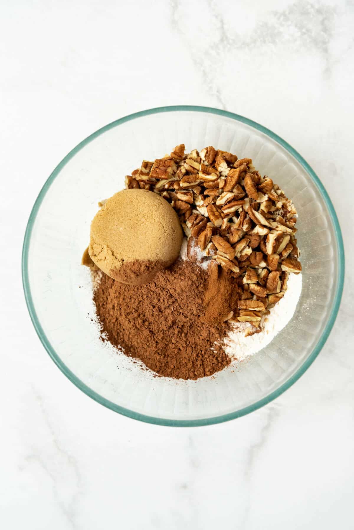 Brown sugar, cocoa powder, chopped pecans, and flour in a bowl.