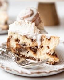 A slice of cinnamon roll cheesecake on a plate.